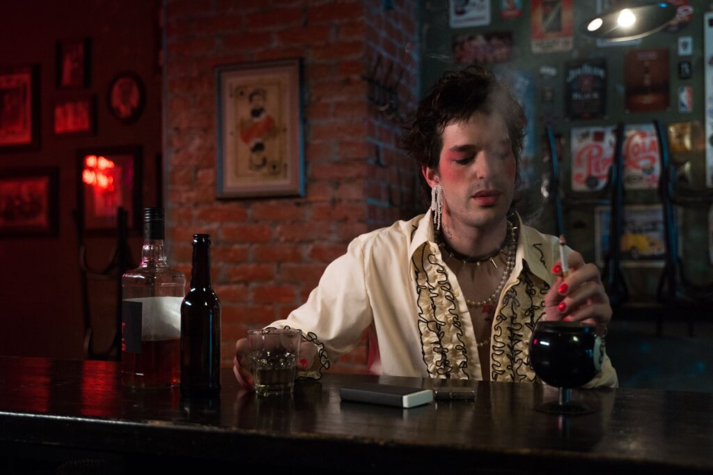 Person at a dimly lit vintage bar, queer nightlife Amsterdam