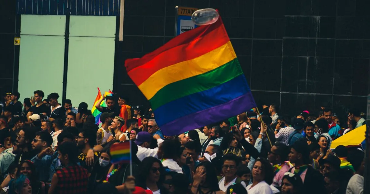 Lively crowd celebrating at a Pride parade with vibrant rainbow flags, Bear Pride Lisbon
