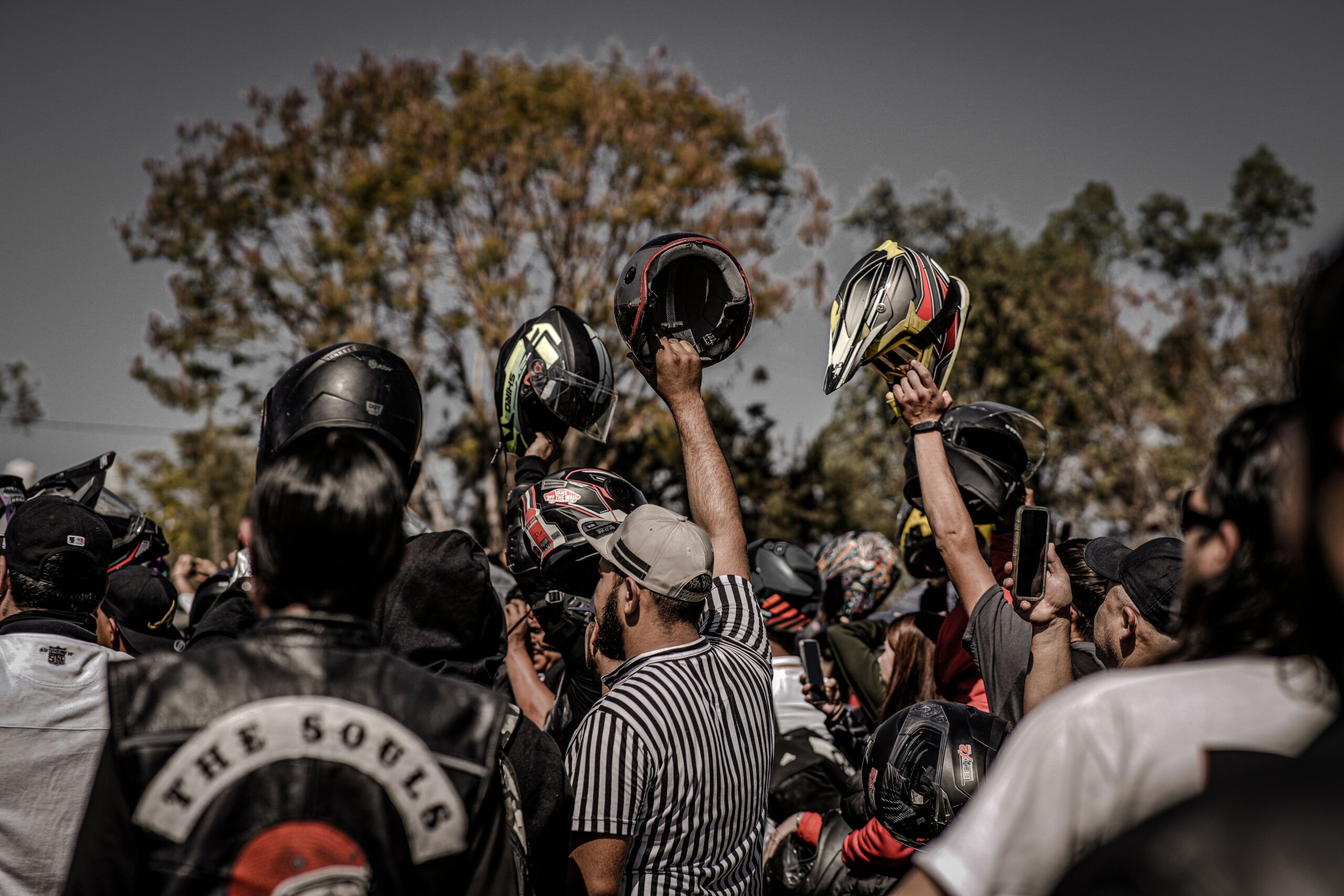 Outdoor gathering raising helmets in celebration, fetish community Lisbon