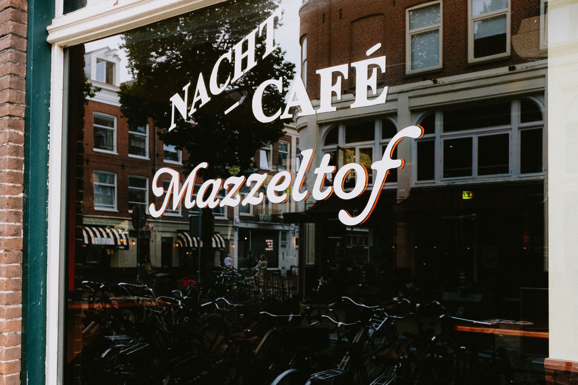 Eagle Amsterdam leather bar exterior on Warmoesstraat at night with illuminated bar signage