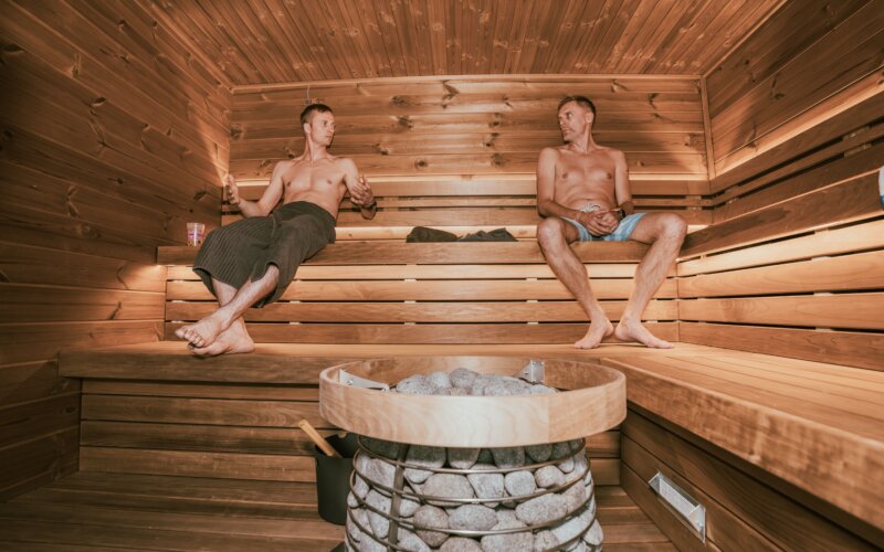 Two men relaxing in a Nordic-designed sauna, gay saunas in Lisbon