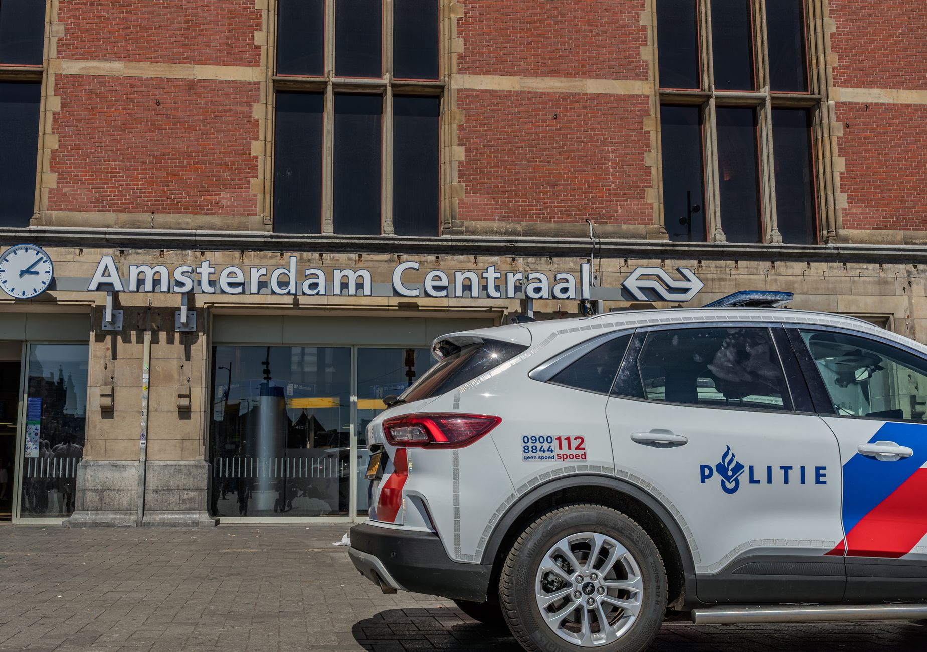 Amsterdam city building exterior with Dutch flag, daytime