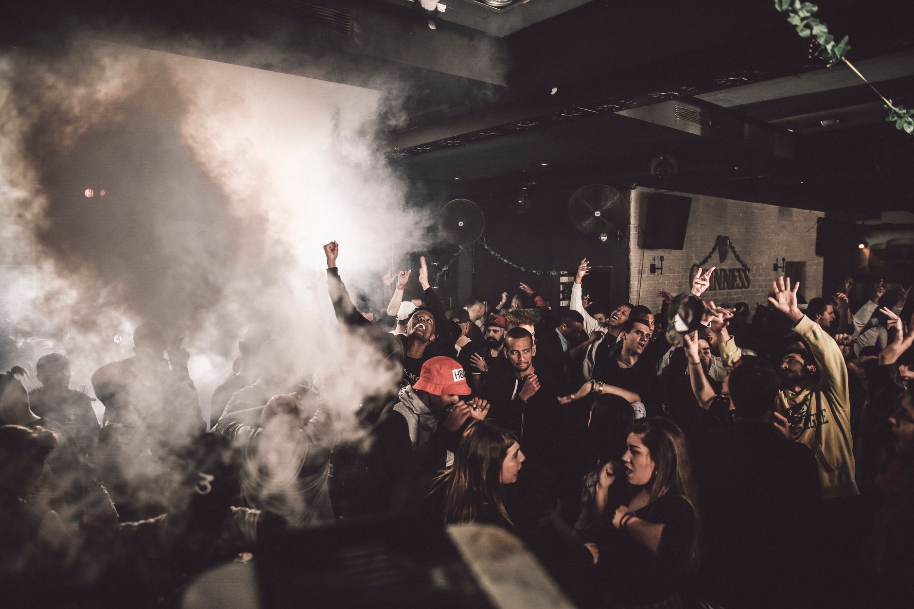 Amsterdam gay club interior with multiple floors bar area and crowd of men under atmospheric low lighting