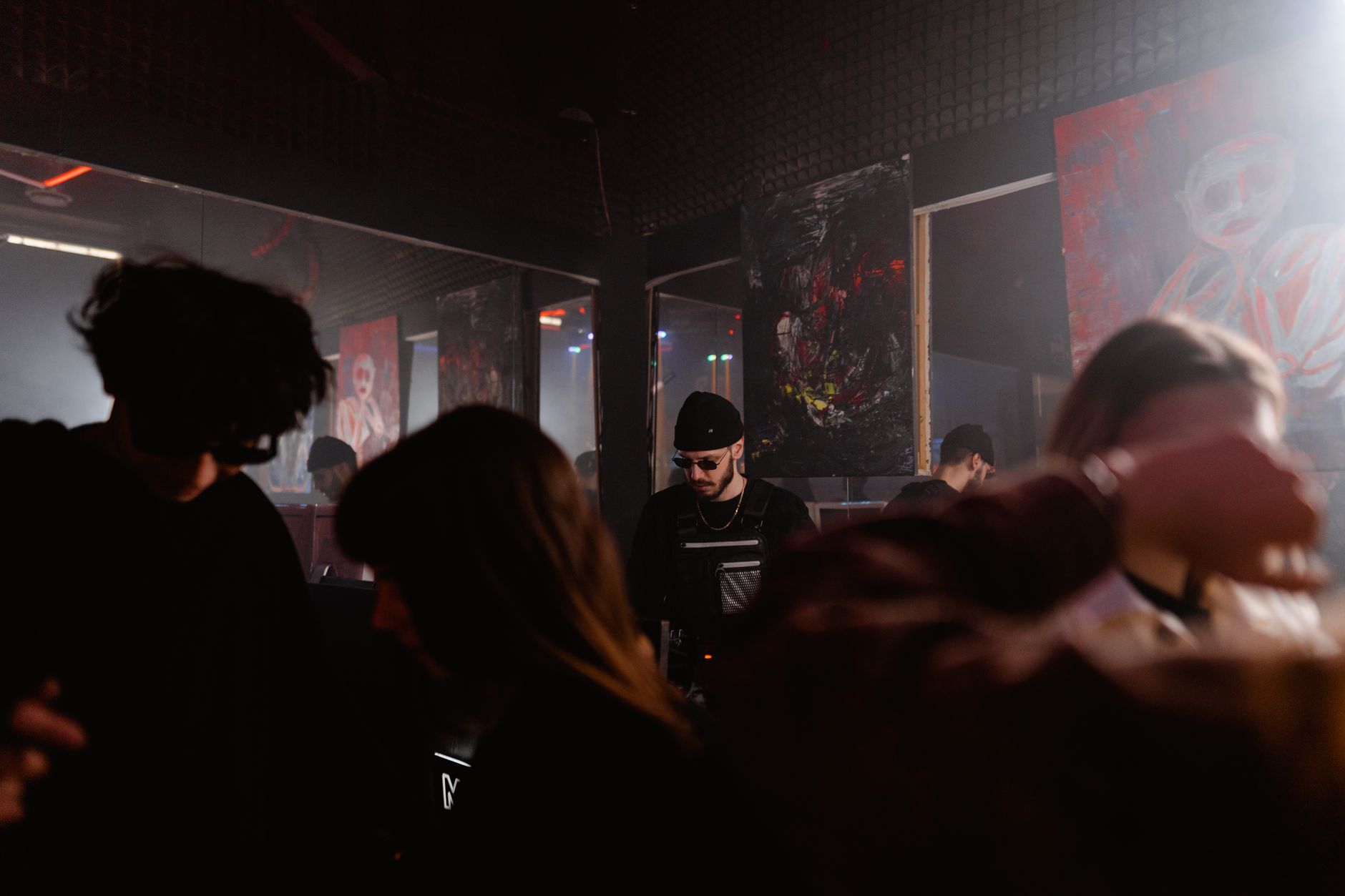 Dark interior of a leather and fetish club with low red lighting and bar area crowd in Amsterdam