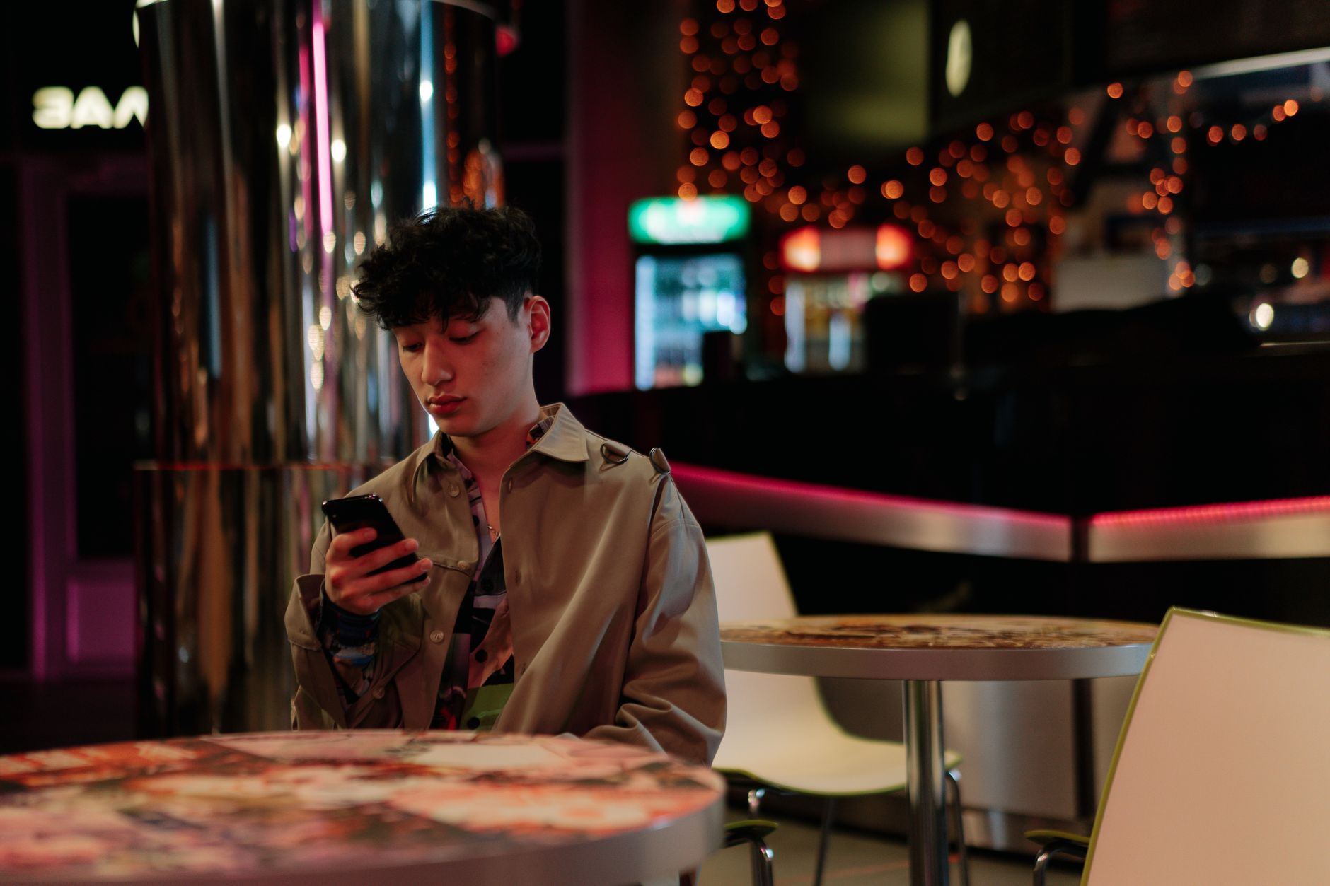 Man checking cruising app on smartphone in Amsterdam bar