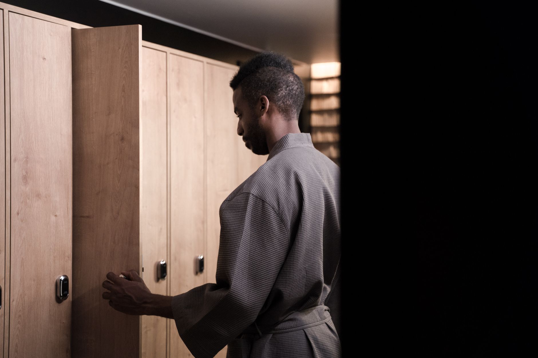 Gay sauna locker area with wooden bench and warm lighting