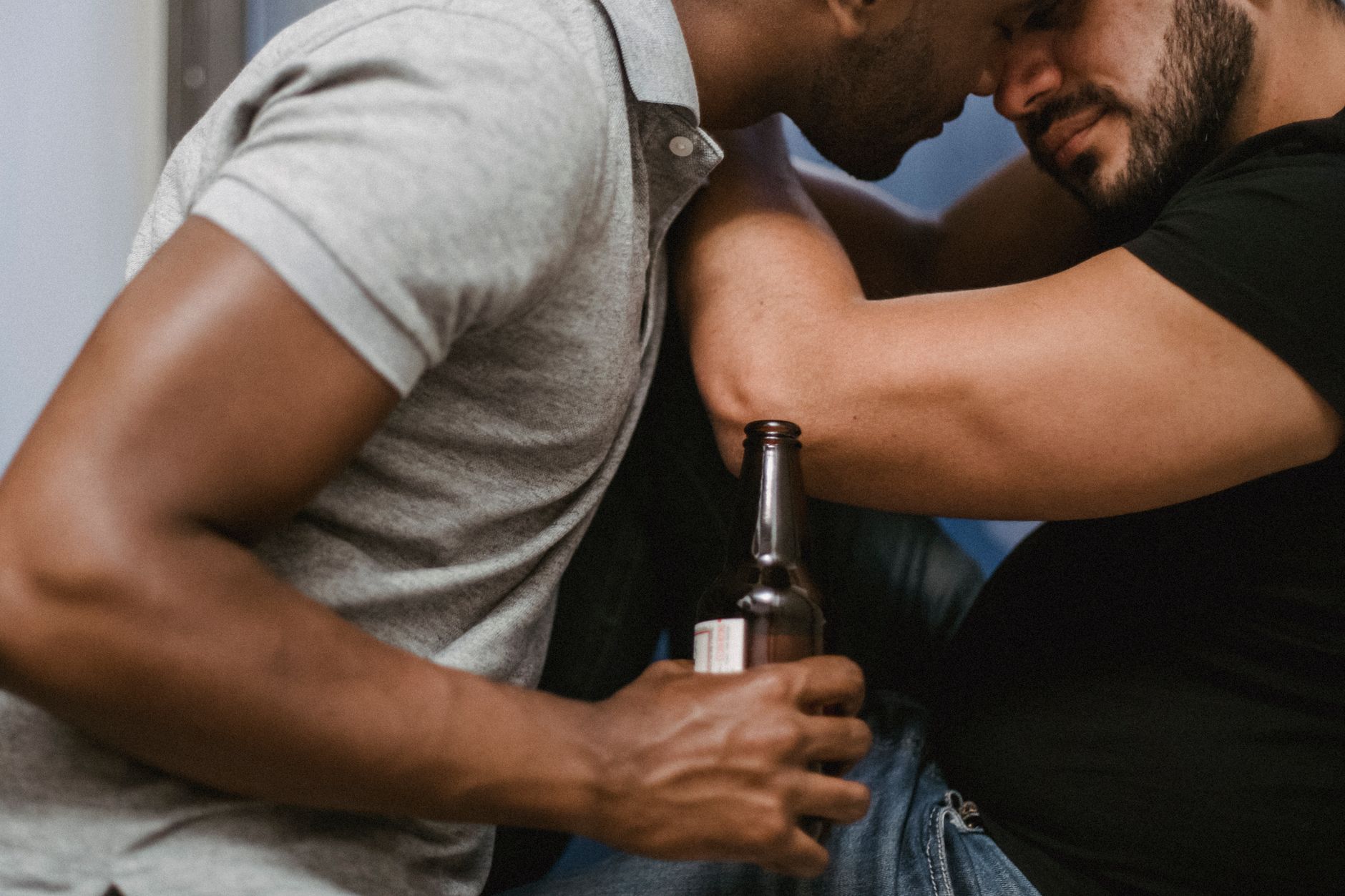 Two men embracing closely, relaxed and connected