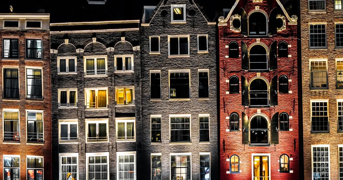 Amsterdam canal houses at dusk, colourful reflections on water