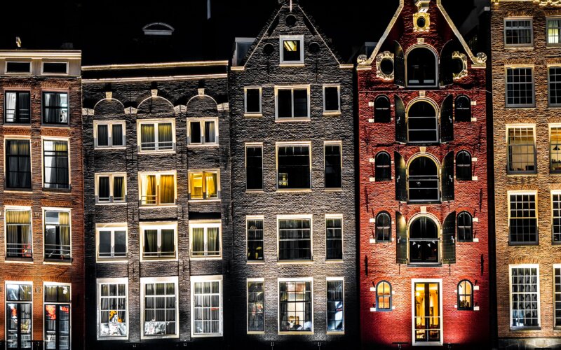 Amsterdam canal houses at dusk, colourful reflections on water