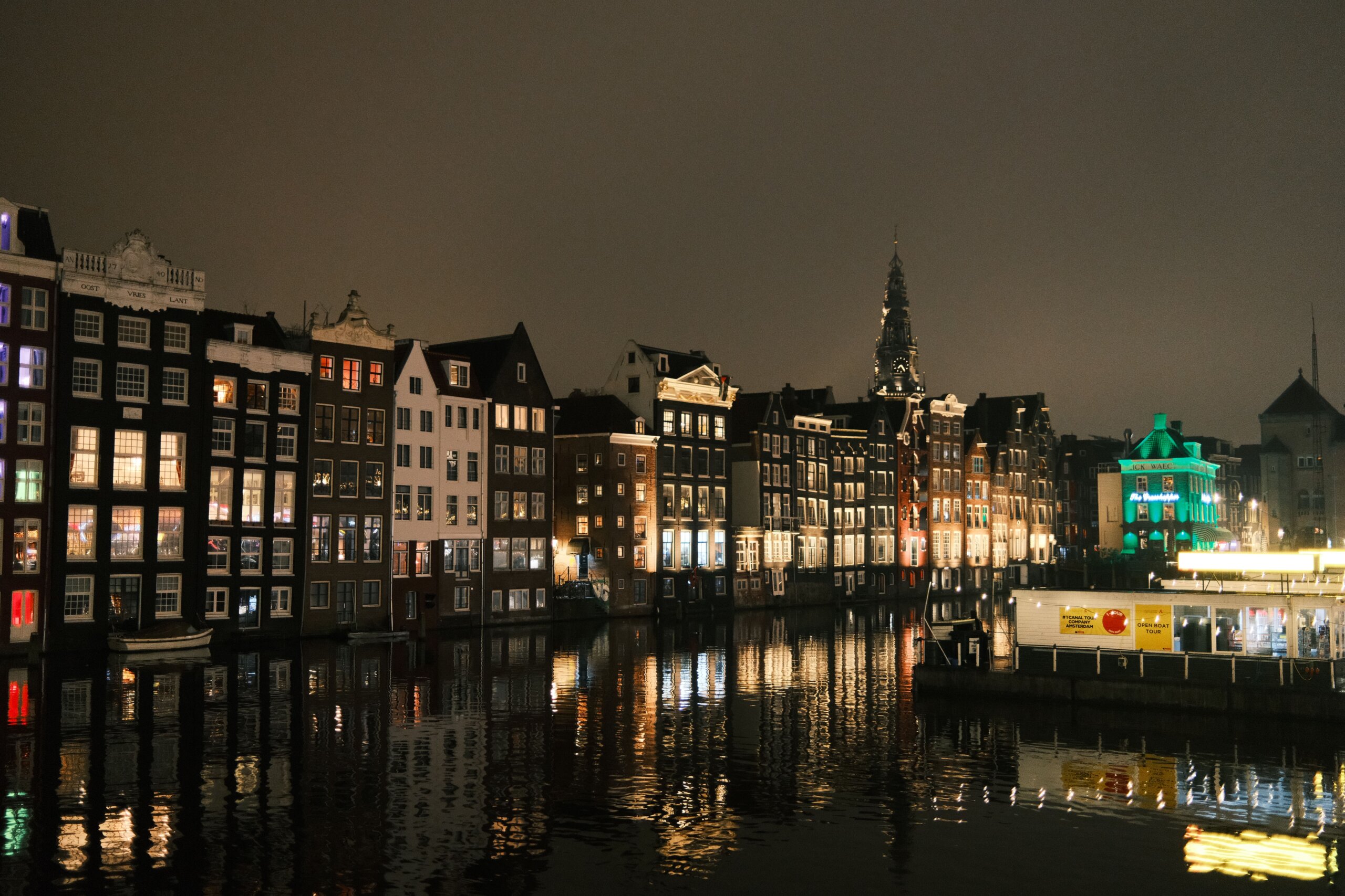 Amsterdam canal houses at night, reflections in dark water
